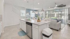 A modern kitchen with a central island, white cabinetry, and pendant lighting. - Free Pool Heat if you Stay in the Month of November (Davenport)