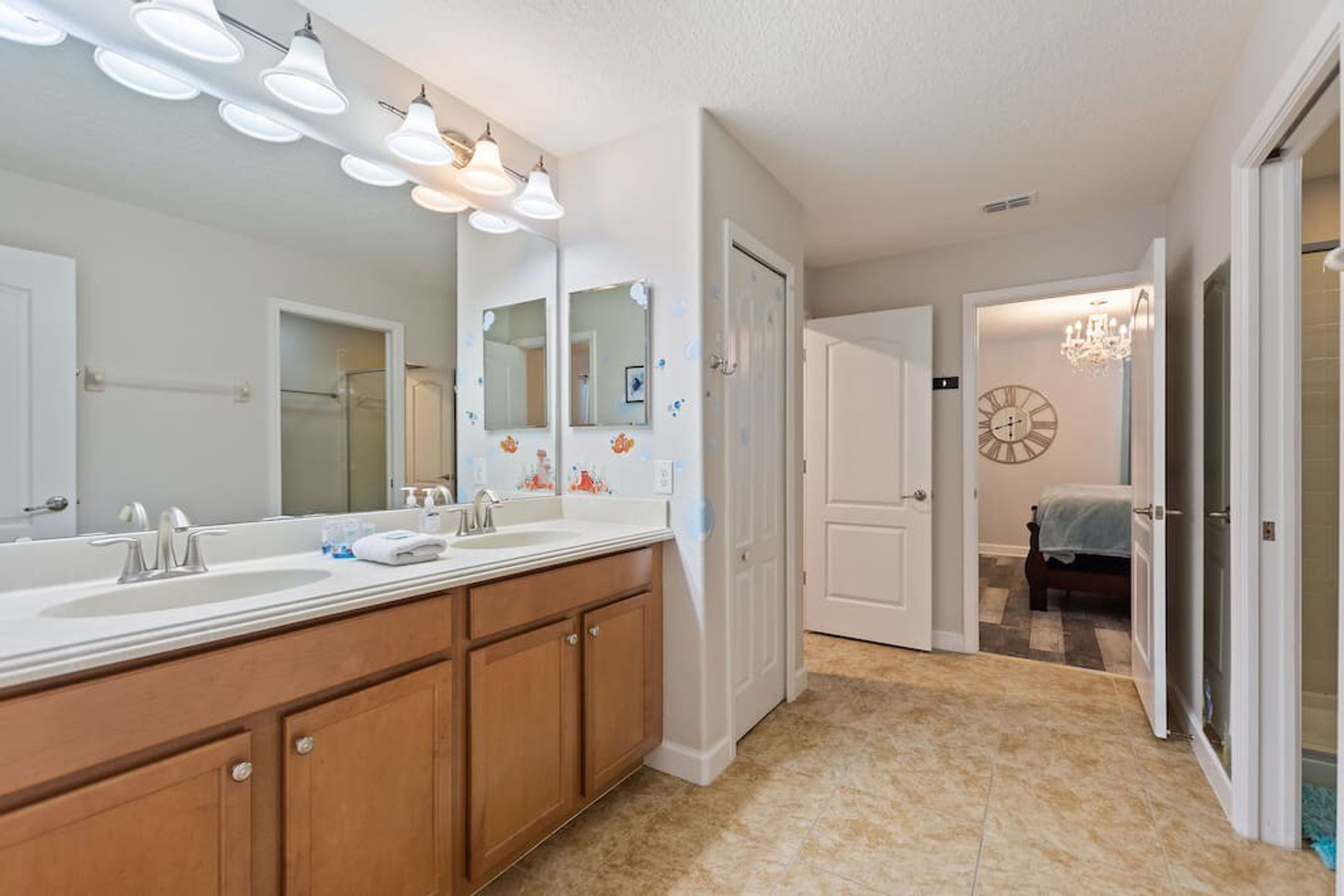 A modern bathroom with a large vanity, double sinks, and a walk-in shower.