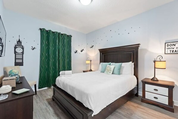 Une chambre à coucher avec un grand lit, un bureau, une chaise, une lampe et une horloge murale.