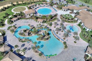 Vue aérienne d’un complexe hôtelier doté de plusieurs piscines, de palmiers et de bâtiments.