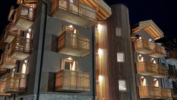 Ein mehrstöckiges Hotel mit Balkonen, einer Stein-Fassade und einem modernen Design.