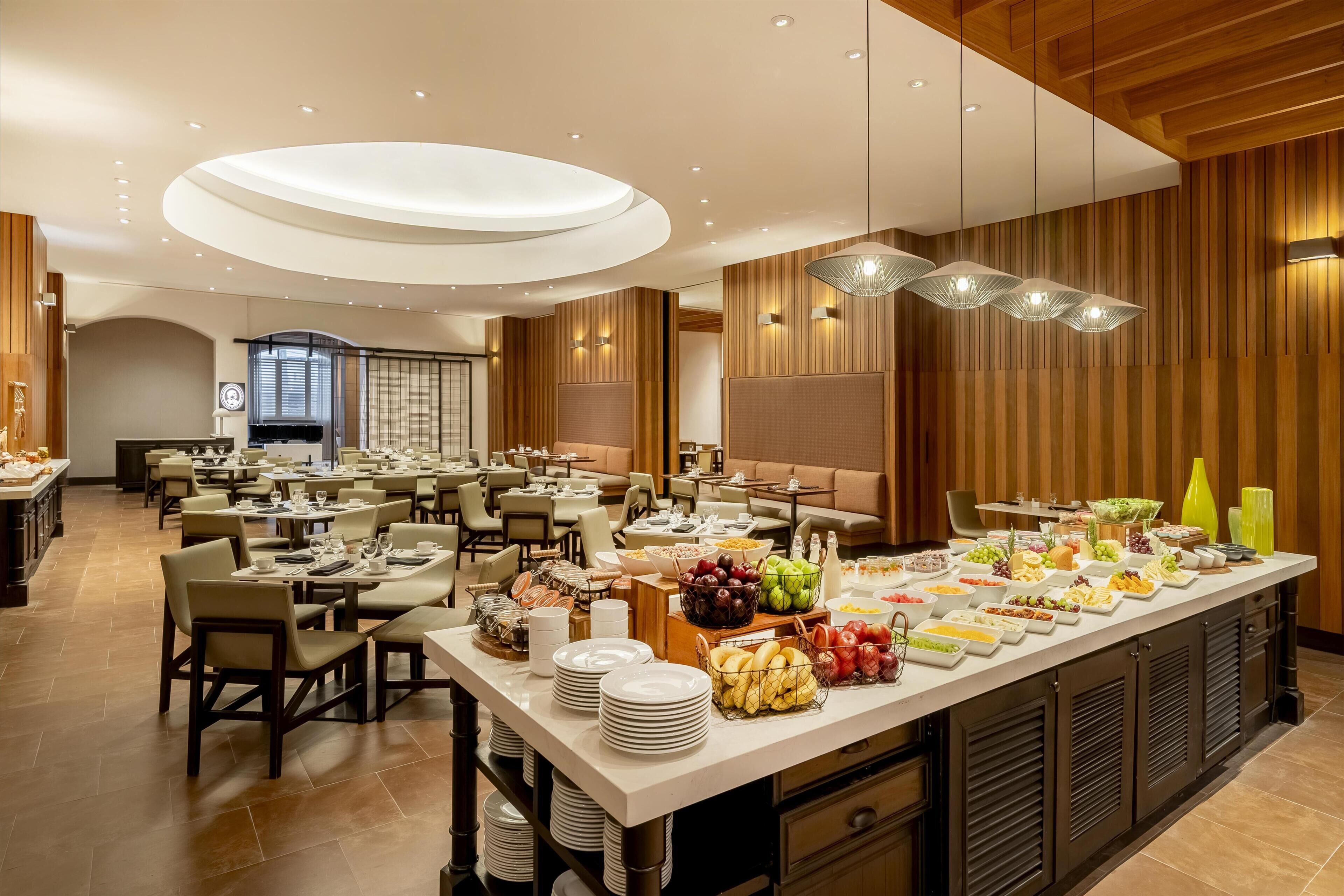 Un grand espace dédié à la salle à manger, avec plusieurs tables et un buffet.