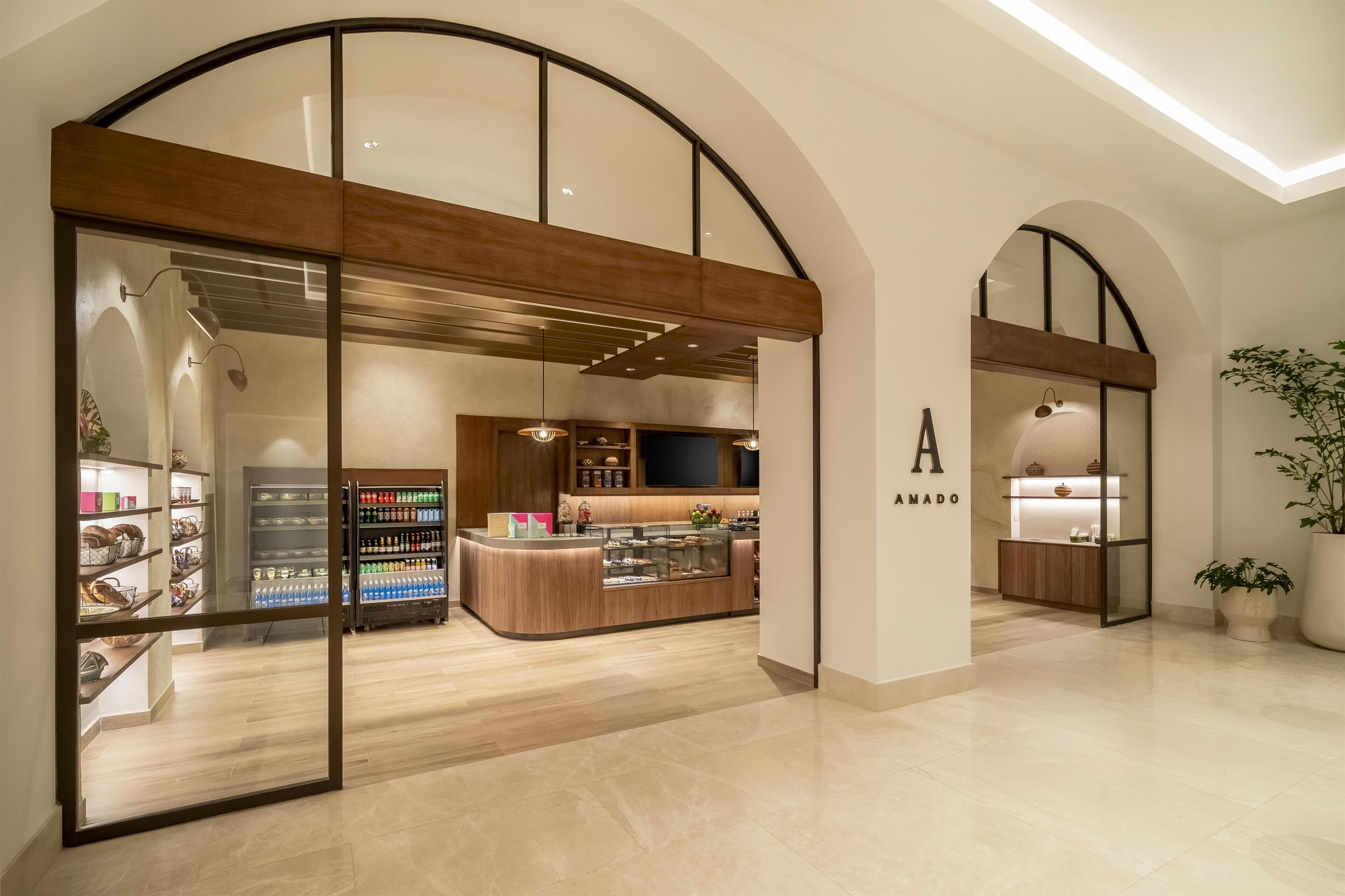 A modern interior with a central counter, glass display cases, and a wooden reception desk.