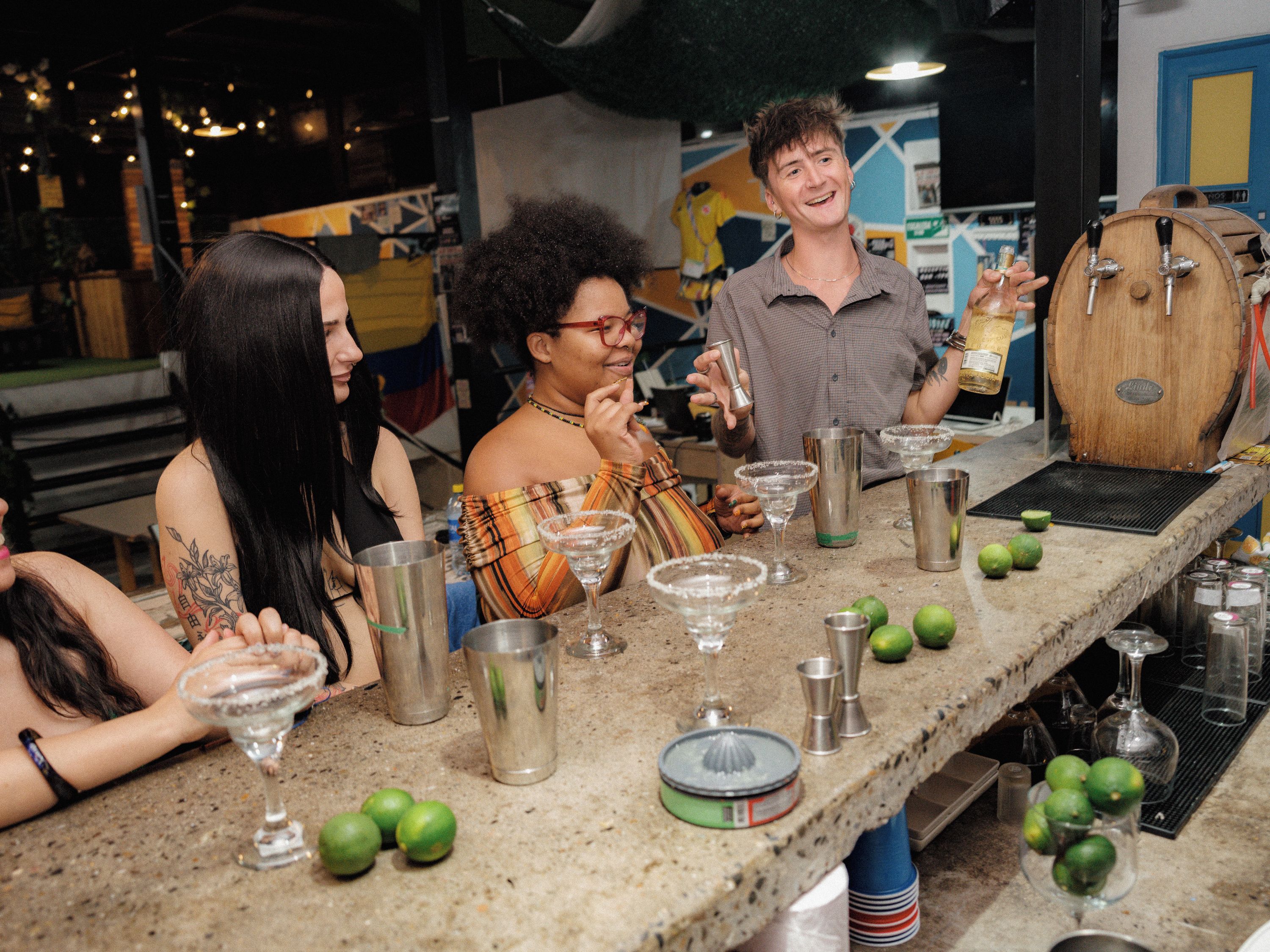 Uma área de bar com um balcão comprido, diversos utensílios e garrafas.