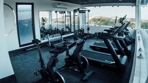 Un gimnasio con cintas de correr, elípticas y equipo de pesas.
