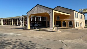 Un motel doté d’un parking central et de plusieurs chambres avec balcon.