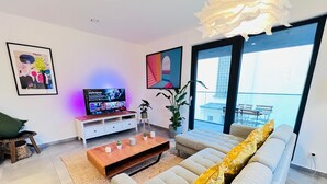 Ein modernes Wohnzimmer mit einer Couch, einem Couchtisch und einem Fernseher.