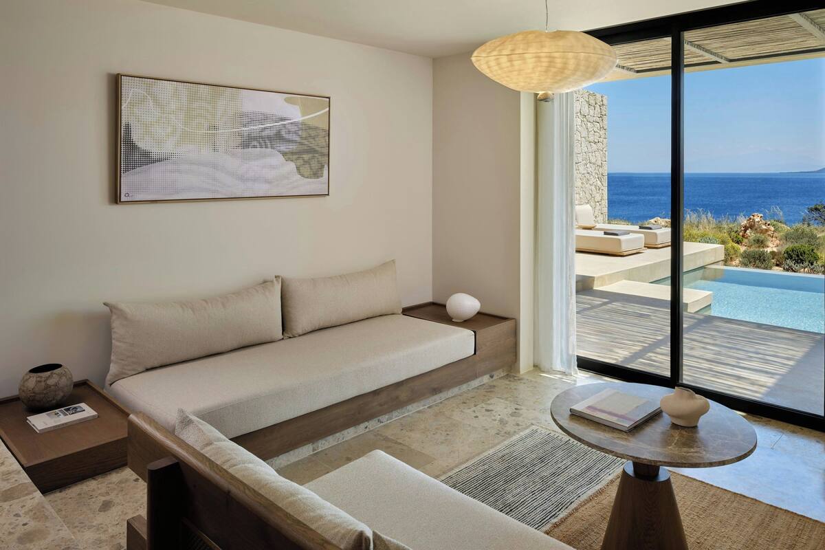 Una habitación moderna con sofá, una mesa redonda y vista al mar.