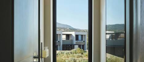 A modern interior with a large window revealing a contemporary building and a landscaped area outside.