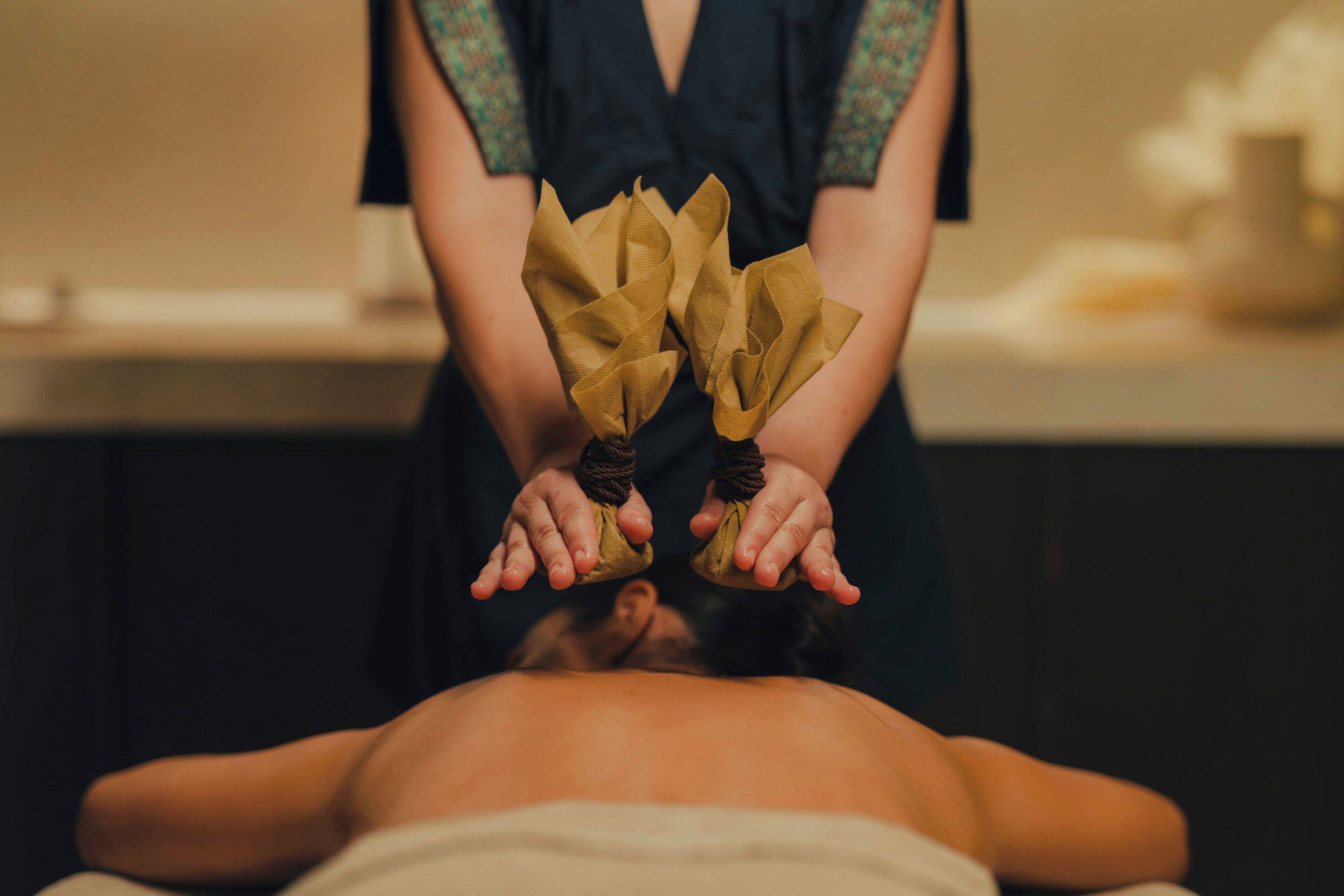 A person receiving a massage with hands wrapped in cloth.