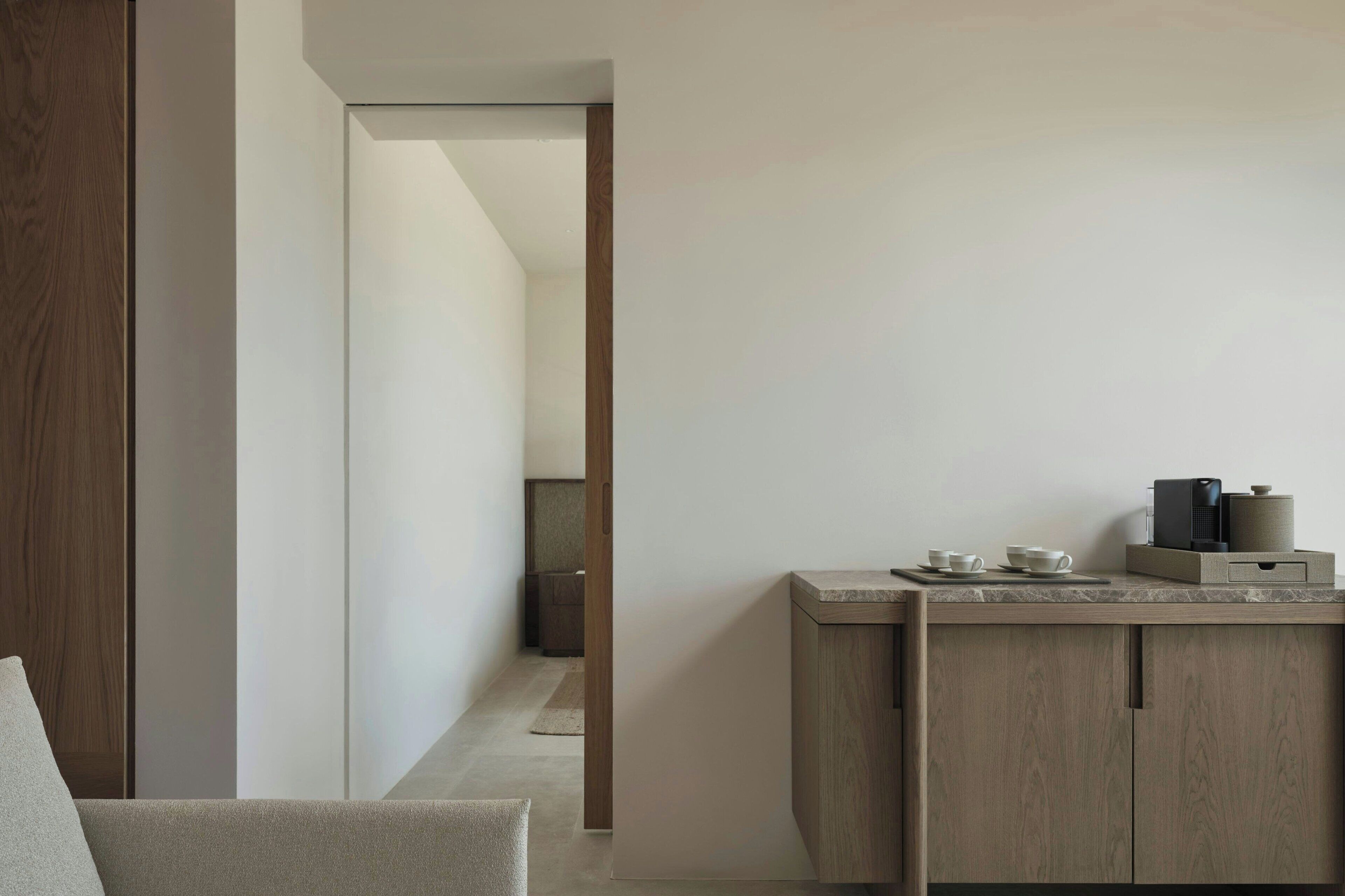 Una cocina moderna con encimera de madera, una cafetera y un mueble pequeño.