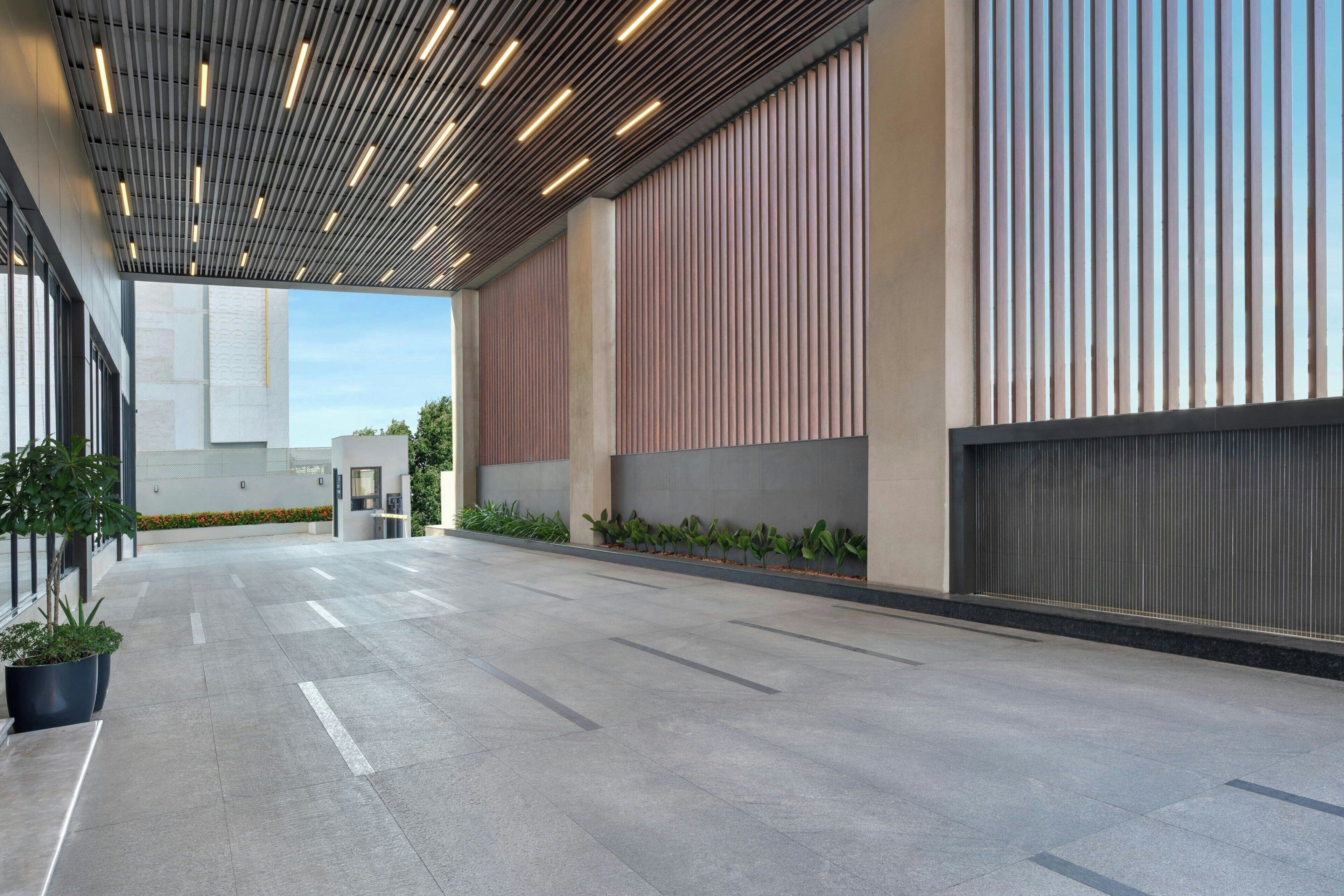 Un espacio interior amplio con un diseño moderno de techo, ventanas grandes y un piso limpio con baldosas.