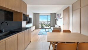 Una cocina moderna con encimera negra, armarios de madera y microondas integrado.