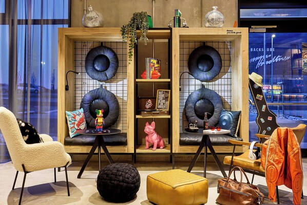 A modern interior with a sofa, ottoman, and a cabinet with shelves.