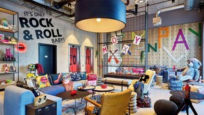 Une salle de jeux pour enfants, pleine de vie, avec une grande fresque murale, des meubles colorés et une décoration ludique.