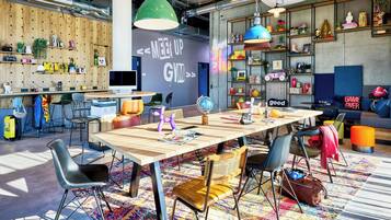 Un ufficio moderno e luminoso, con un ampio tavolo di legno, diverse sedie e scaffali pieni di oggetti assortiti.