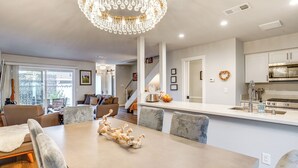 Een moderne keuken met witte kasten, roestvrijstalen apparatuur en een centraal eiland.