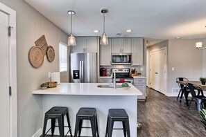 A modern kitchen with a central island, stainless steel appliances, and pendant lighting. - New Owner Special!  Quiet Oasis in Denver (Denver)