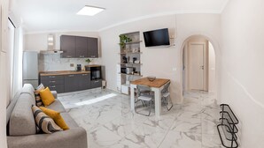 A modern apartment with a kitchen, dining area, and living room. - Elegant tourist accommodation facing metro C (Roma)