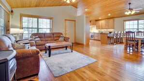 A spacious living room with a sofa set, a coffee table, and a dining area with chairs and a table. - Norfork Lake Access: Cabin w/ Deck & Water View! (Elizabeth)
