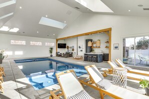 A modern indoor pool area with lounge chairs, a bar, and a kitchen in the background. - Private Pool & Hot Tub: Luxe Unit Near UTA Train! (American Fork)