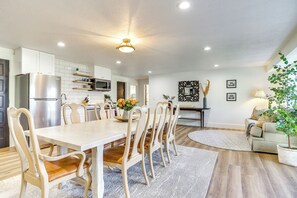 A modern kitchen with white cabinets, a stainless steel refrigerator, and a dining area with wooden chairs and a table. - Private Pool & Hot Tub: Luxe Unit Near UTA Train! (American Fork)