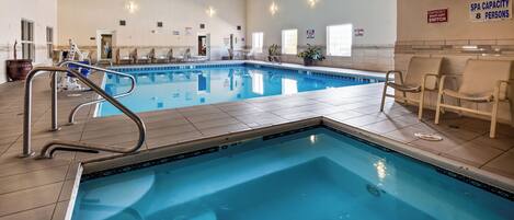 Piscina con deck de azulejos, sillas de descanso y un cartel que indica una capacidad de spa para 8 personas.