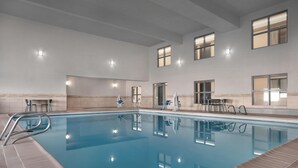 An indoor swimming pool with clear water, surrounded by tiled walls and a high ceiling. - Spark By Hilton Albuquerque North I-25 (Albuquerque)