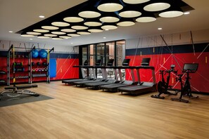 Ett gym med löpband, motionscyklar och utrustning för styrketräning.