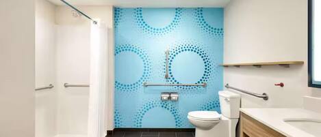 A modern bathroom with a shower, toilet, and sink.