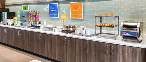 A breakfast counter with various food options and a sign that reads "TOP IT BREAKFAST".