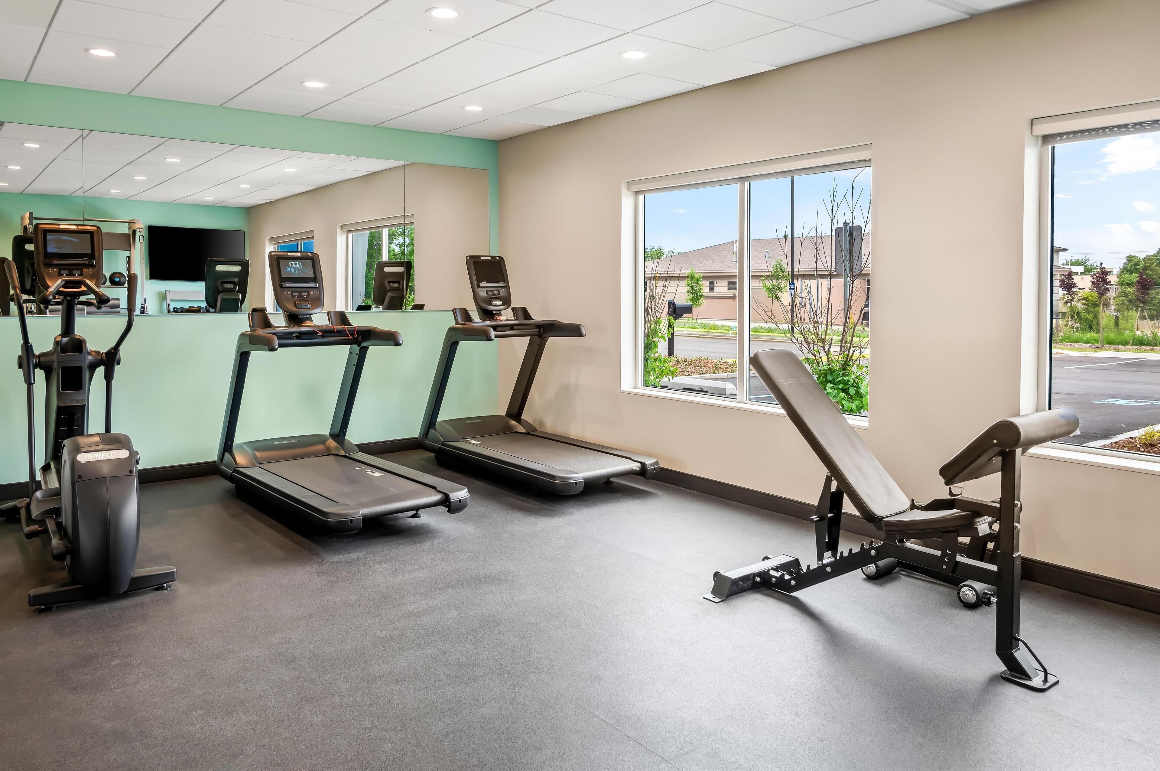 A gym with treadmills, a stationary bike, and a rowing machine.