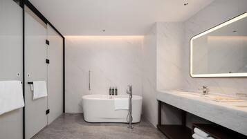 A modern bathroom with a freestanding bathtub, a large mirror, and a vanity with a countertop.