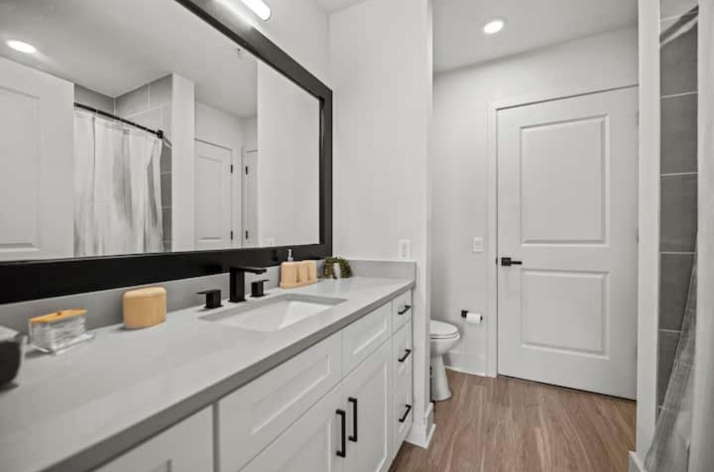Een moderne badkamer met een grote spiegel, twee wasbakken en een toilet.
