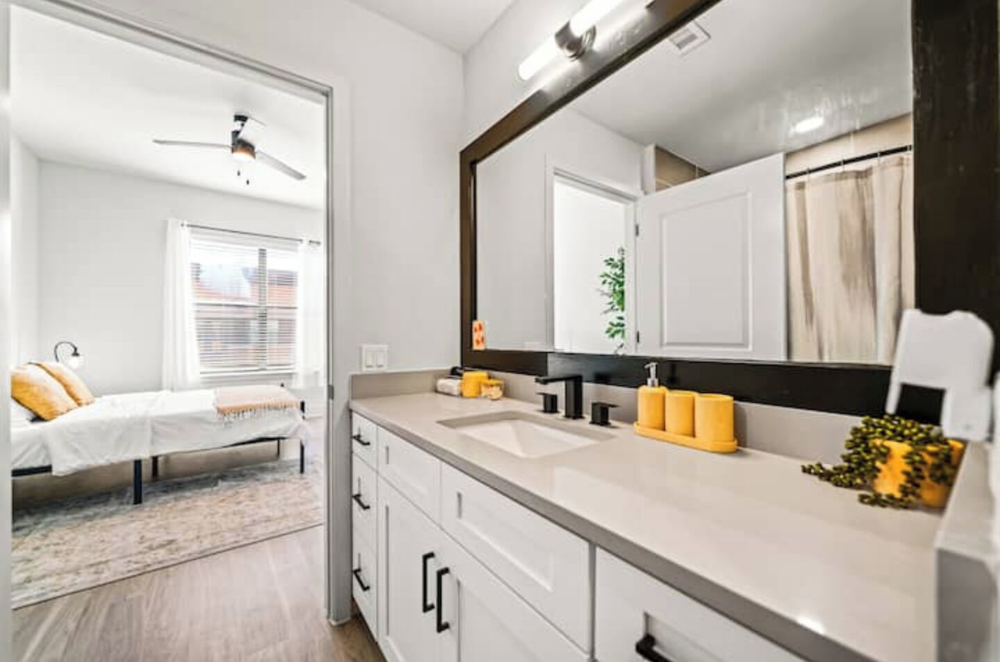 Un baño moderno con un espejo grande, lavamanos dobles y zona de ducha.