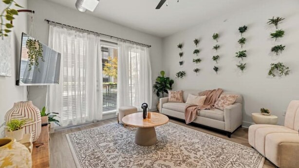 Una sala de estar moderna con una mesita de centro redonda, un sofá y un tapiz decorativo.