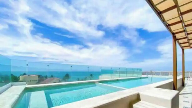 A rooftop infinity pool with a clear view of the ocean and a covered seating area. - Luxury Apartment 50m from Beach in Bucerías w/ Balcony & Rooftop Garden (Bucerías)