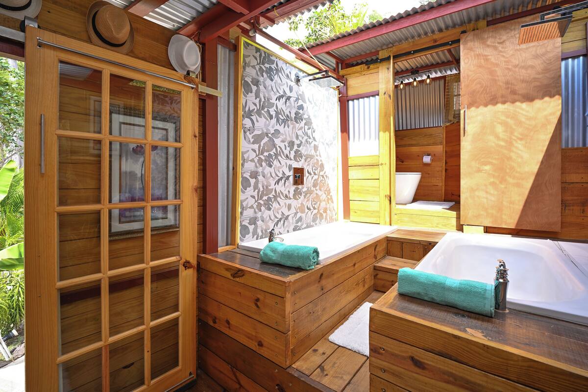 Une salle de spa en bois, équipée d’une baignoire, d’un banc en bois et d’une grande fenêtre.