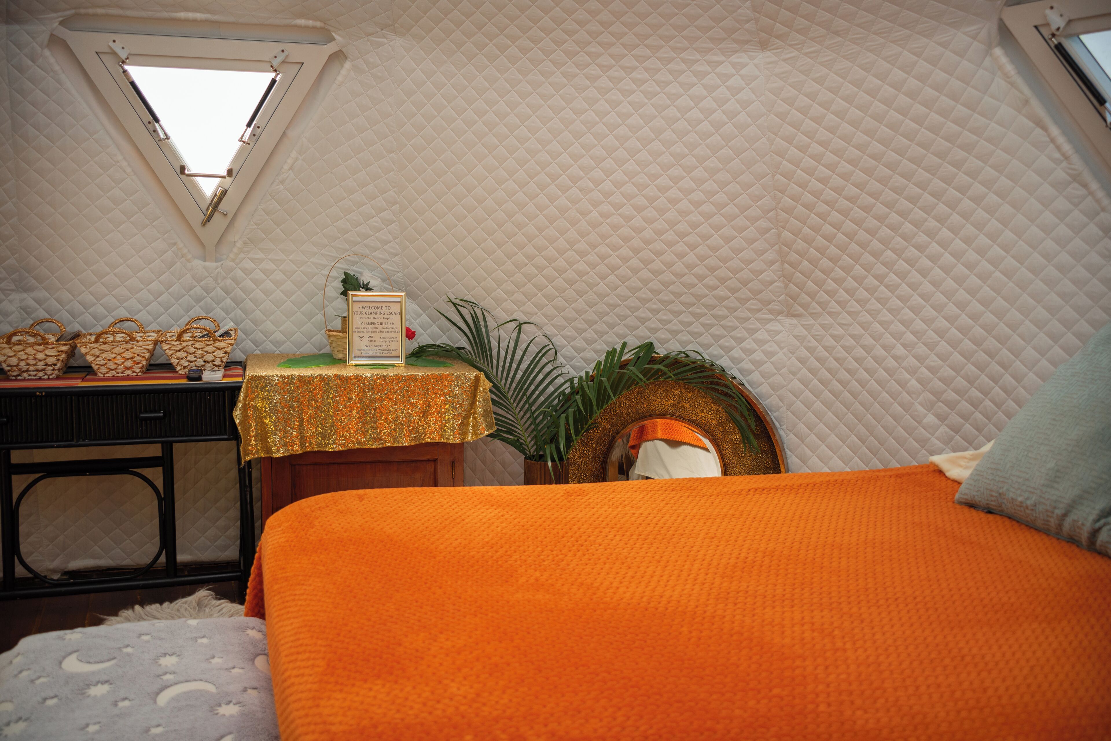 Ein gemütliches Zimmer mit Bett, Schreibtisch, Fenster und einem kleinen Tisch mit Körben.