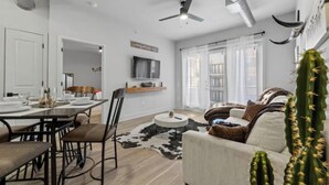 Ein modernes Wohnzimmer mit Essbereich, Deckenventilator und einer Sukkulente.