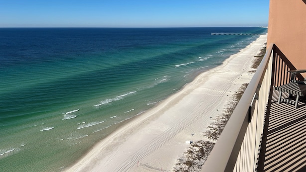 Un balcón con vista a una playa y al océano.