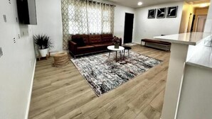 A modern living room with a sofa, coffee table, and rug.