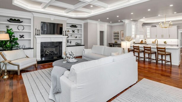 A spacious living room with a fireplace, white sofas, and a dining area with bar stools. - The Wren + Nest | Main & Guest House | Sleeps 10 (Columbia)