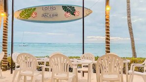 A snack bar named 'Lol-Ha' with a view of the ocean and a sailboat in the distance.