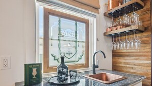 A kitchen with a granite countertop, a copper sink, and a window with a decorative glass panel. - Beautifully renovated 3BR house, off street parking in the Marigny Triangle (New Orleans)