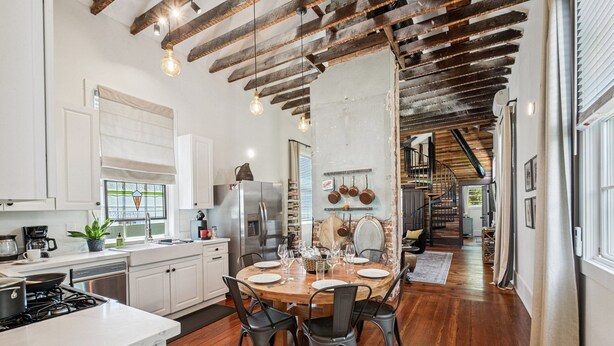 A spacious kitchen with a wooden dining table set for four, surrounded by modern appliances and a large window. - Beautifully renovated 3BR house, off street parking in the Marigny Triangle (New Orleans)