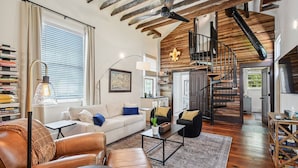 A modern living room with a leather sofa, coffee table, and a staircase leading to an upper level. - Beautifully renovated 3BR house, off street parking in the Marigny Triangle (New Orleans)