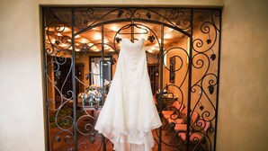 A wedding dress hanging in front of a wrought iron gate. - The Vineyard House in the Pastures of Heaven (Corral de Tierra)