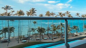 A balcony with a view of the ocean and palm trees.