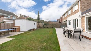 Un patio trasero residencial con un patio, una mesa y sillas.